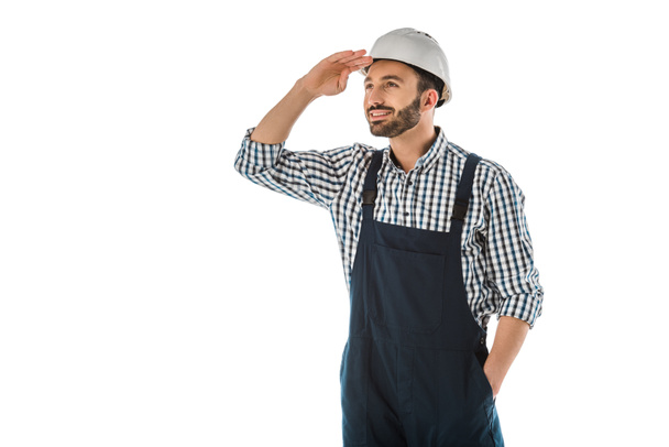 happy construction worker in overalls and helmet looking up isolated on white - Photo, Image