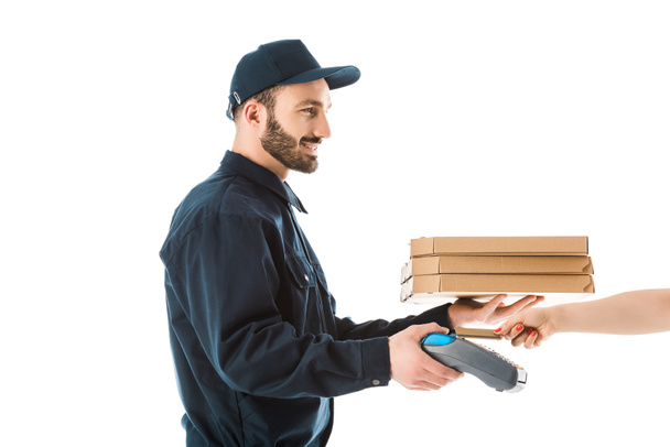 partial view of female hand with credit card near cheerful delivery man holding payment terminal and pizza boxes isolated on white - Photo, Image