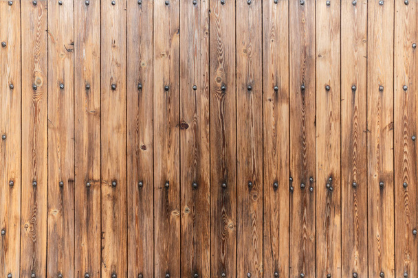 Brown rustic wood wall covering made of vertical boards with big decorative nails - Фото, зображення