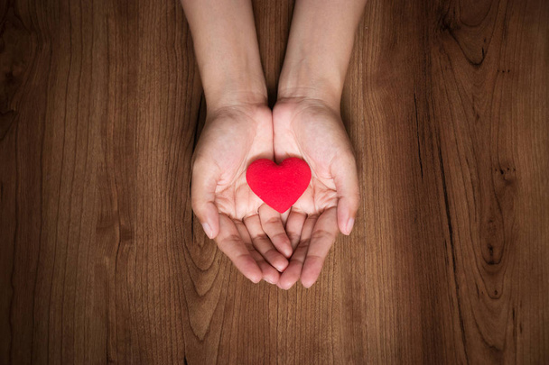 Frauenhände mit rotem Herz. Valentinstag, Gesundheitsfürsorge, Spendenkonzept, Weltherztag.  - Foto, Bild