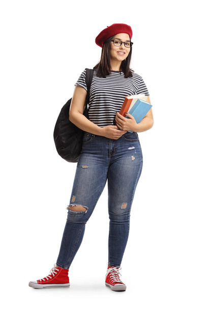 Full length portrait of a female student posing with books in her hands isolated on white background - Photo, image