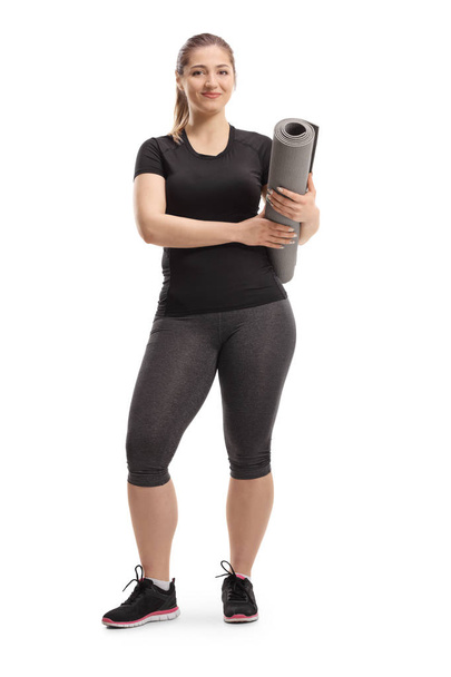 Full length portrait of a young woman posing with an exercising mat isolated on white background - Fotografie, Obrázek