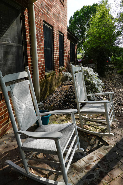 St. Mary, Μέριλαντ, Ηνωμένες Πολιτείες οι λευκές κουνιστές καρέκλες κάθονται σε έναν κήπο. - Φωτογραφία, εικόνα
