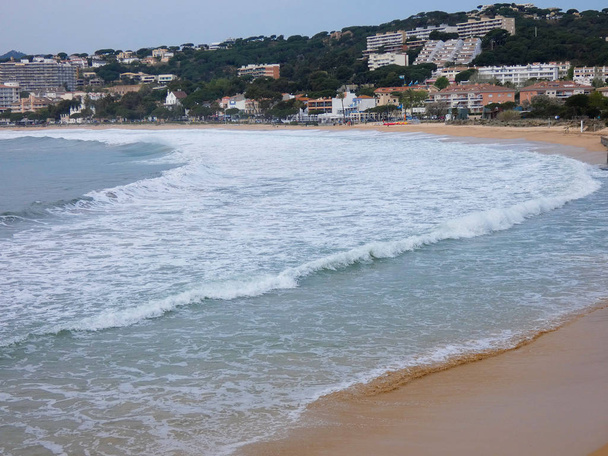 великі хвилі падають на пісок і скелі узбережжя
 - Фото, зображення