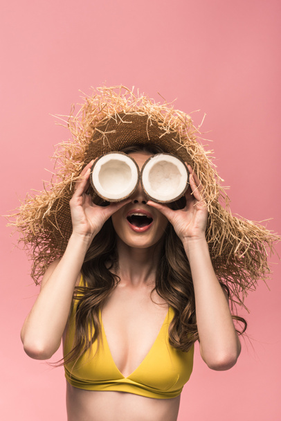 cheerful girl in straw hat holding coconuts isolated on pink - Fotoğraf, Görsel