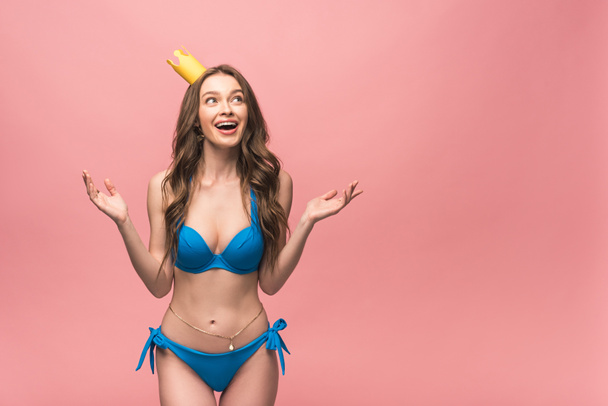 excited girl in bikini and crown isolated on pink - Photo, Image