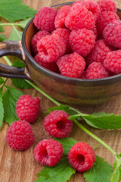 Fresh raspberry in a cup on wooden table - Photo, Image