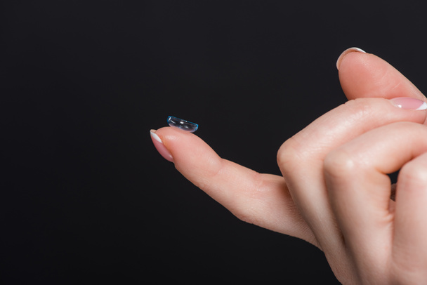 oříznutý pohled ženy přidržovaná kontaktní čočky izolované na černém  - Fotografie, Obrázek