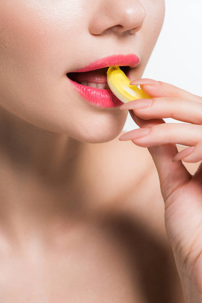 cropped view of girl eating yellow jelly candy isolated on white  - Fotó, kép