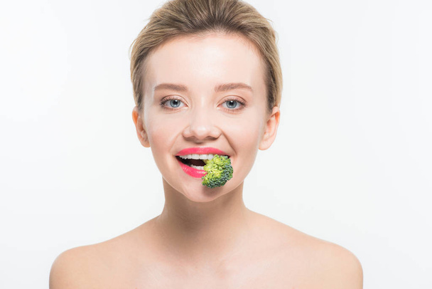 attractive naked woman eating green ripe broccoli isolated on white   - 写真・画像
