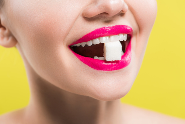 cropped view of happy woman eating sugar cube isolated on yellow  - Photo, Image