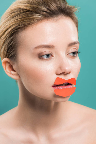beautiful naked young woman with orange paper on lips isolated on blue  - Fotoğraf, Görsel