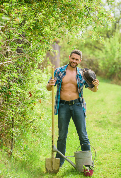 Arbor day. Planting trees. Commitment and responsibilities. Agriculture concept. Planting in garden. Tree planting tradition. Growing plants. Man handsome muscular torso with watering can and shovel - Fotoğraf, Görsel