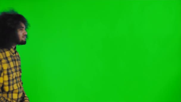 African American man walking in the frame, received a new message on his phone on green screen or chroma key background. Concept of emotions - Footage, Video