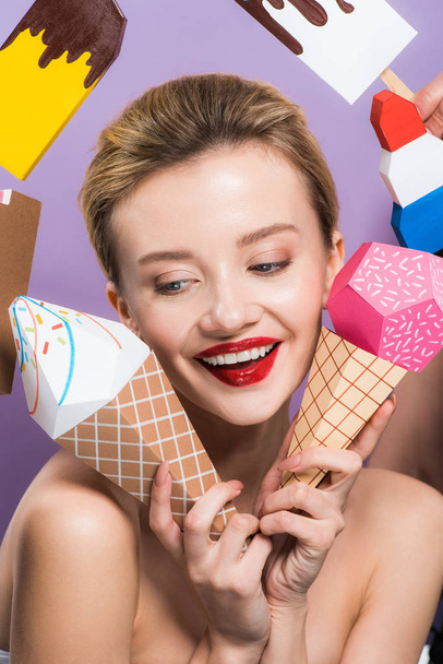 cheerful naked woman holding decorative ice cream cones isolated on purple  - Photo, Image