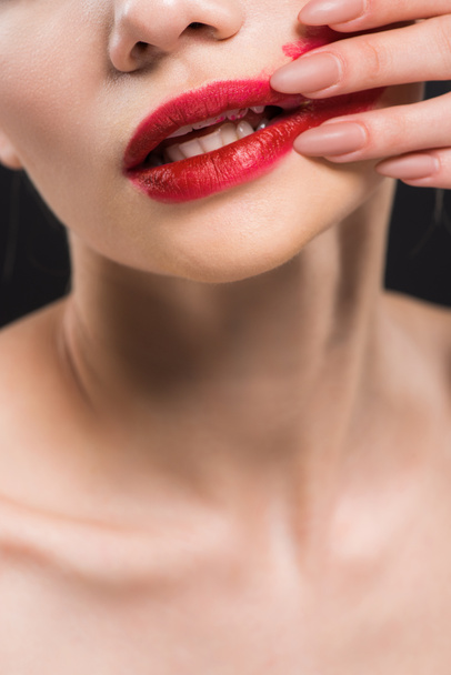 cropped view of naked girl removing red lipstick from lips isolated on black  - Φωτογραφία, εικόνα
