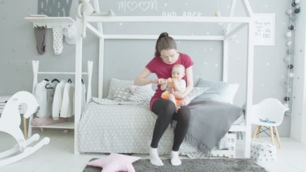 Caring mother brushing baby in childrens room - Metraje, vídeo
