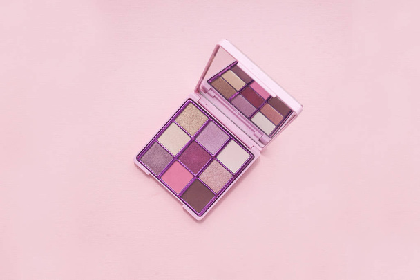 top view Palette of pink cosmetic make up with a mirror on pink background, colorful shadows minimalism, on light pink background - Valokuva, kuva