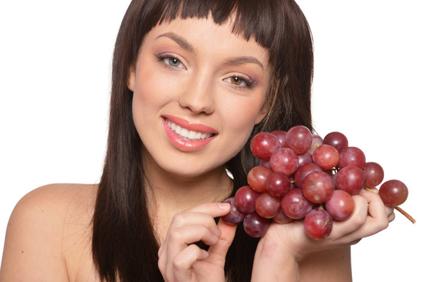 Portret van jonge vrouw poseren met druiven geïsoleerd op witte achtergrond - Foto, afbeelding