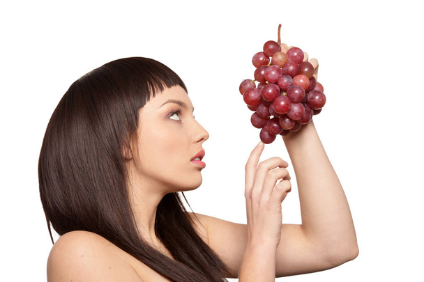 Portrait of young woman posing  with grapes  isolated on white background - Photo, image