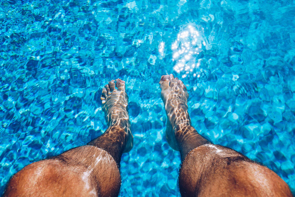 スイミングプールでリラックスできます。水泳のうんちの隣でリラックスする男 - 写真・画像