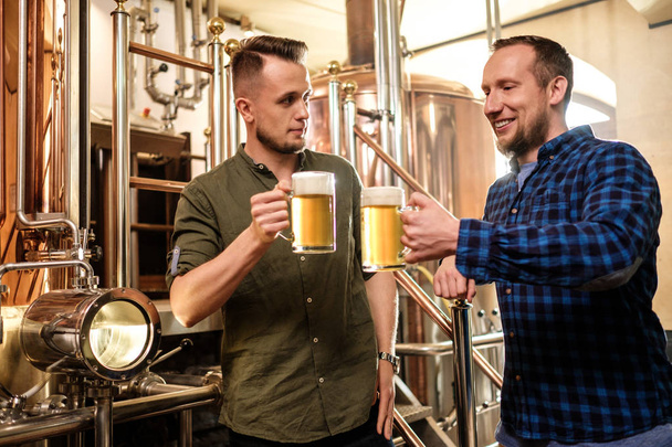 zwei Männer probieren frisches Bier in einer Brauerei - Foto, Bild