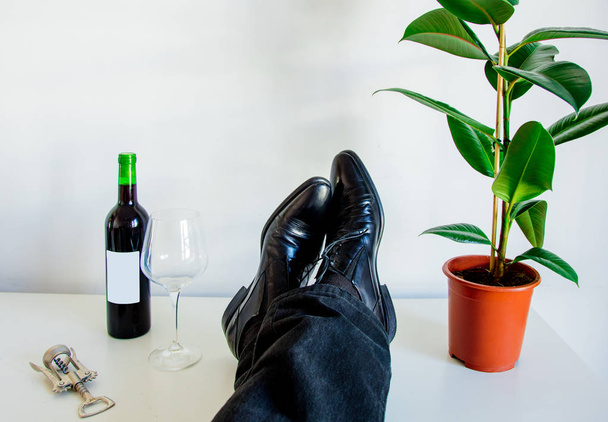 Male foots in low shoes and ficus plant with next to glass and r - Photo, Image