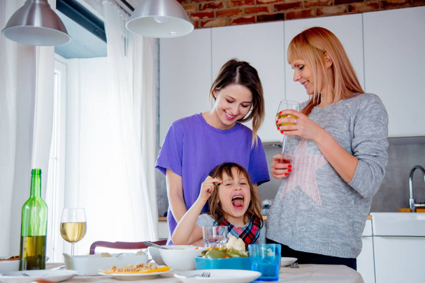 junge lesbische Familie mit einem Mädchen in der Küche.  - Foto, Bild