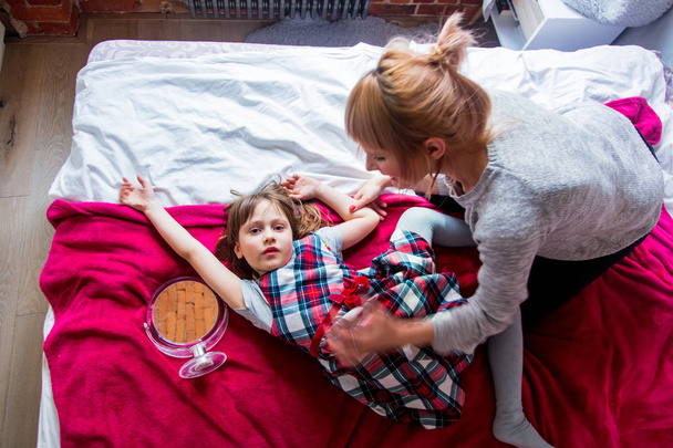 Madre e figlia si divertono in un letto a casa
 - Foto, immagini
