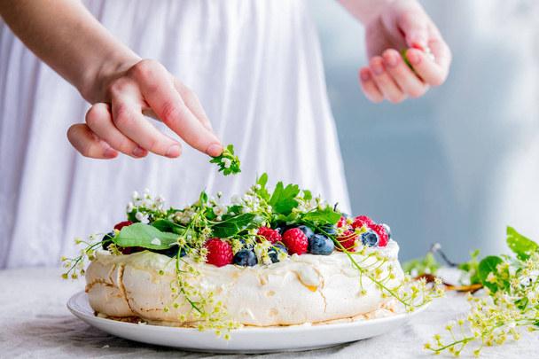 ženské ručičky cukrářských šéfkuchařových dekorují Krémový koláč s větvemi - Fotografie, Obrázek