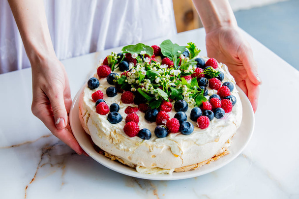 ženské ručičky cukrářských šéfkuchařových dekorují Krémový koláč s větvemi - Fotografie, Obrázek