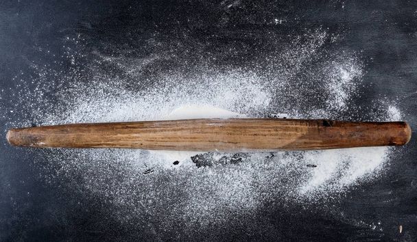 wooden rolling pin on a black background, top view - Foto, immagini