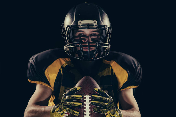 American football player isolated on the black background - Фото, зображення