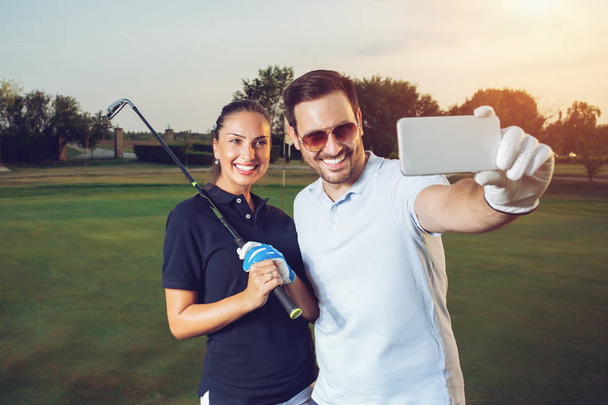 Young couple making selfie on a golf course - Фото, зображення