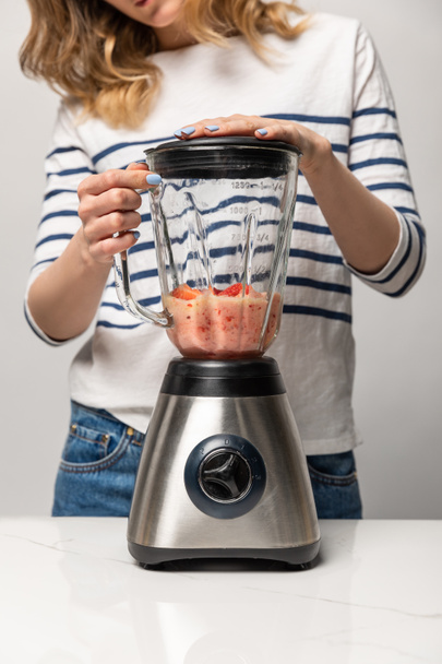 cropped view of woman preparing tasty smoothie in blender on white  - Foto, Imagen