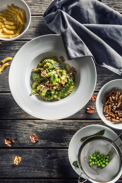 Pasta Fusilli con jamón de guisantes verdes y nueces. cocina italiana o mediterránea
 - Foto, imagen