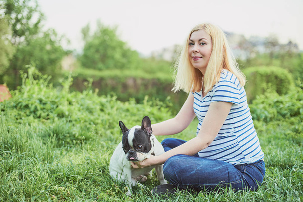 glückliche schwangere Frau spielt mit ihrem Haustier im Park - Foto, Bild