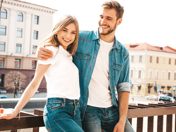 Portrait of smiling beautiful girl and her handsome boyfriend in casual summer clothes. Happy cheerful family having fun on the street background. Hugging - Foto, imagen