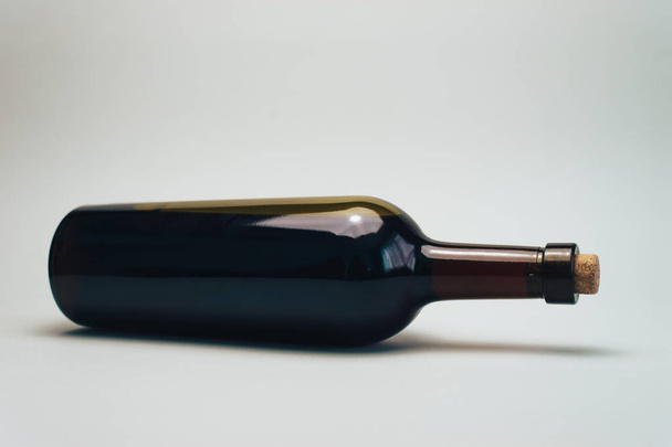 Bottle of red wine on a old oak wooden table and gray background. - Fotografie, Obrázek