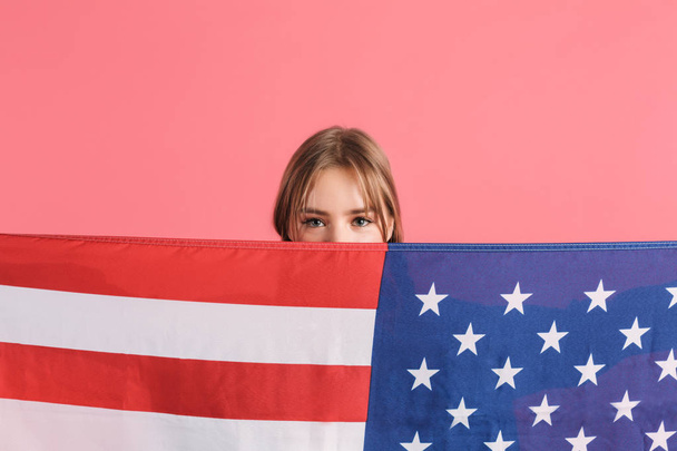 Portrait of pretty girl covering mouth with big american flag wh - Фото, зображення