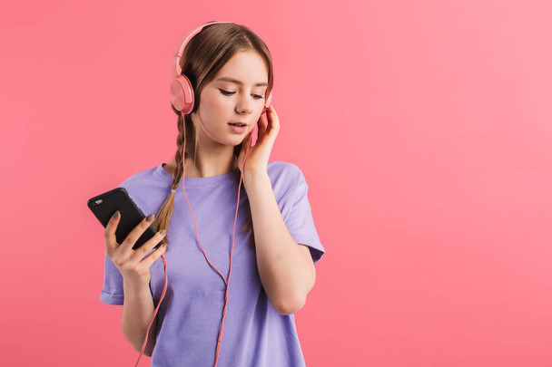 Joven chica atractiva con dos trenzas en camiseta lila escuchando
 - Foto, Imagen