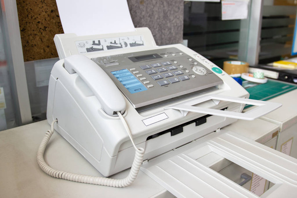 De faxmachine voor het verzenden van documenten in het kantoorconcept apparatuur die nodig is in functie - Foto, afbeelding