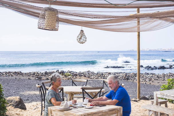 Başarılı emeklilik eğlencesi, yaz tatili konsepti. Emekli olgun çift kumsalda güneşli güzel bir günün tadını çıkarıyor..  - Fotoğraf, Görsel
