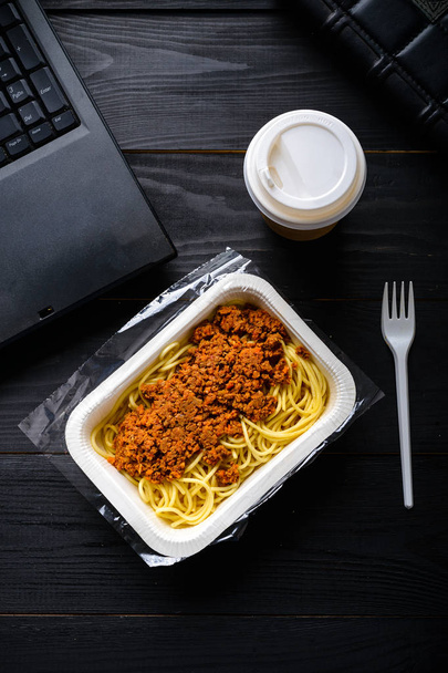 Mittagessen im Büro, gefrorene Spaghetti Bolognese auf dem Tisch - Foto, Bild