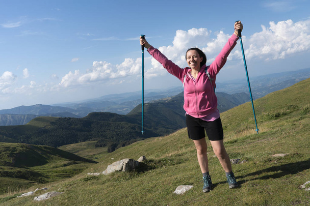 Giovane Ragazza con UNA vistosa felpa Rosa esulta sorridente Durante UNA Escursione Sulle Montagne v UNA soleggiata Giornata primaverile - Fotografie, Obrázek