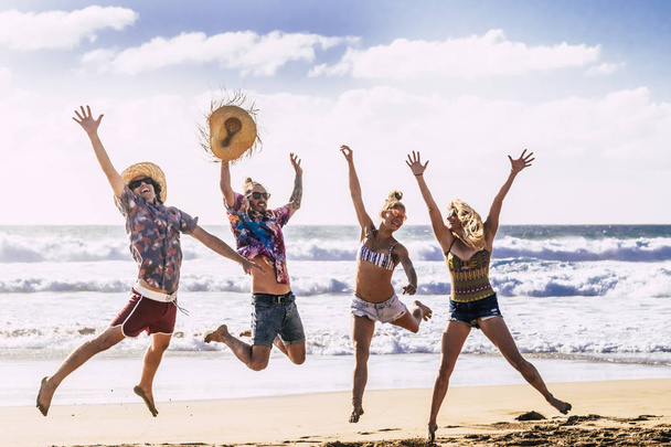 Ryhmä ystäviä hauskaa ja pelaa rannalla lähellä merta päivällä
 - Valokuva, kuva