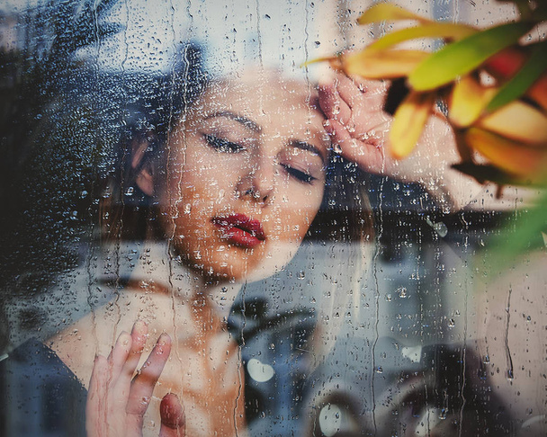 junge traurige Frau am nassen Fenster, nachdem der Regen den Plan verfehlt hat - Foto, Bild