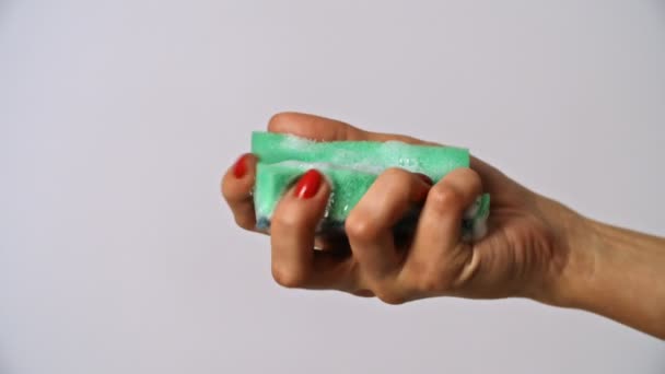 Γυναίκα συμπίεση πράσινο σφουγγάρι στο χέρι - Πλάνα, βίντεο