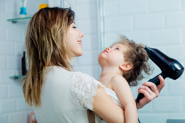 молодая мать и сын сушат волосы после душа
 - Фото, изображение