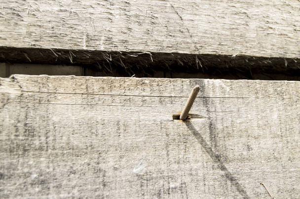 Primer plano de los viejos clavos oxidados que sobresalen de las tablas viejas oscuras, textura de madera, superficie de tono vintage
 - Foto, imagen